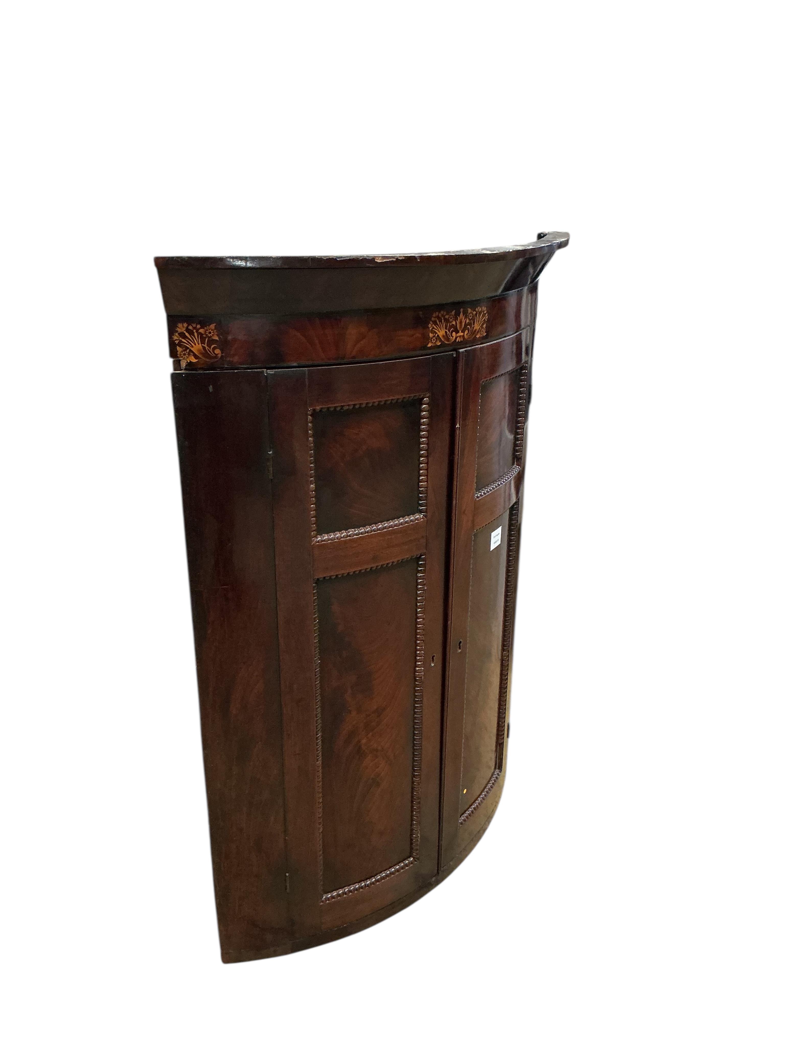 A George IV inlaid mahogany bow fronted hanging corner cupboard, width 80cm, depth 54cm, height 108cm